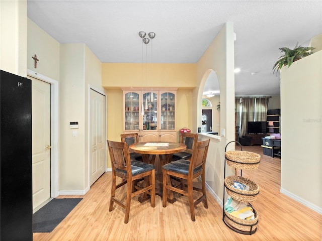1319 Castleport Rd, Winter Garden, FL 34787 - dining space featuring light wood-style flooring, arched walkways, and baseboards