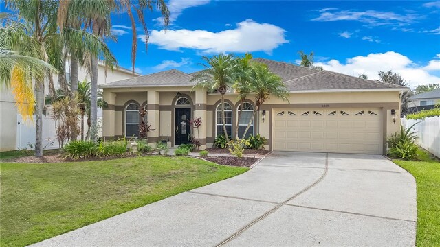 1319 Castleport Rd, Winter Garden, FL 34787 - ranch-style house with stucco siding, a garage, a front lawn, and driveway