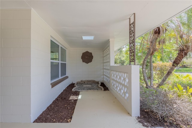 view of property exterior with concrete block siding and a porch
