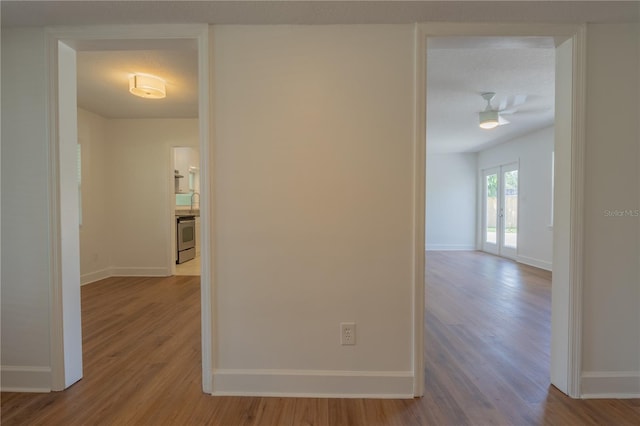 hall with wood finished floors and baseboards