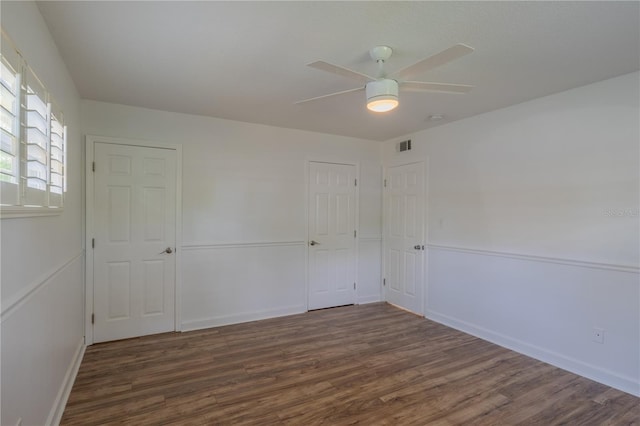 unfurnished room featuring wood finished floors, a ceiling fan, and baseboards