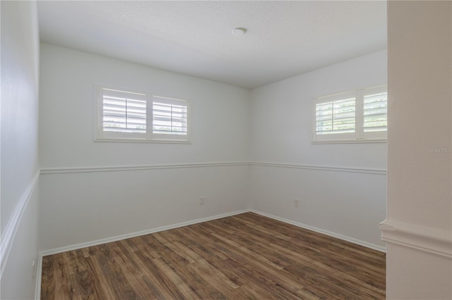 empty room featuring wood finished floors and baseboards