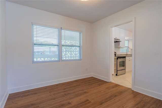 spare room featuring light wood-style flooring and baseboards