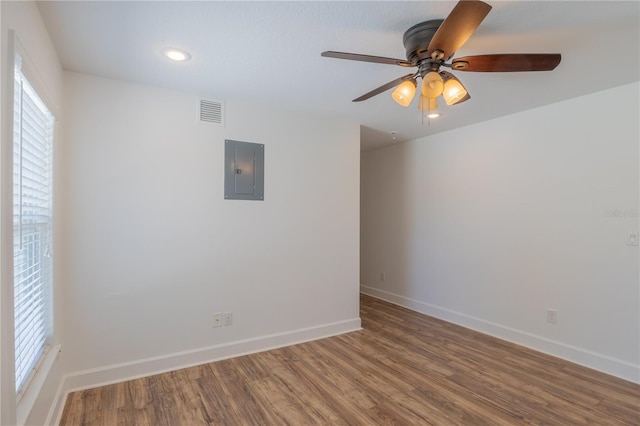 empty room featuring electric panel, wood finished floors, baseboards, ceiling fan, and recessed lighting