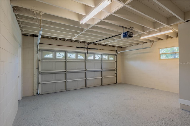 garage with a garage door opener and concrete block wall