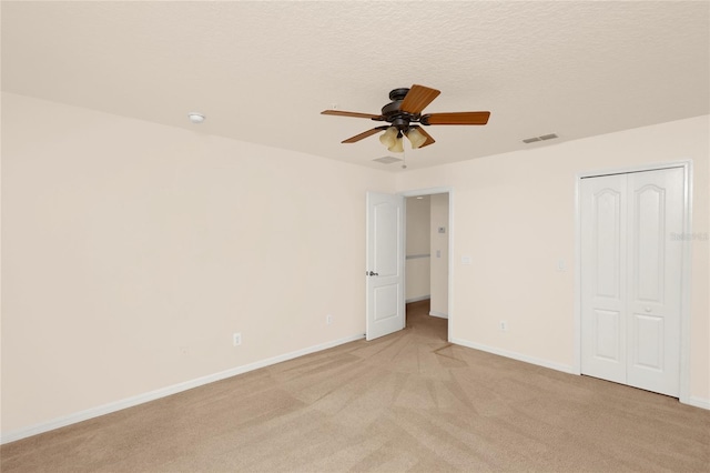 unfurnished bedroom featuring light colored carpet, baseboards, a closet, and ceiling fan