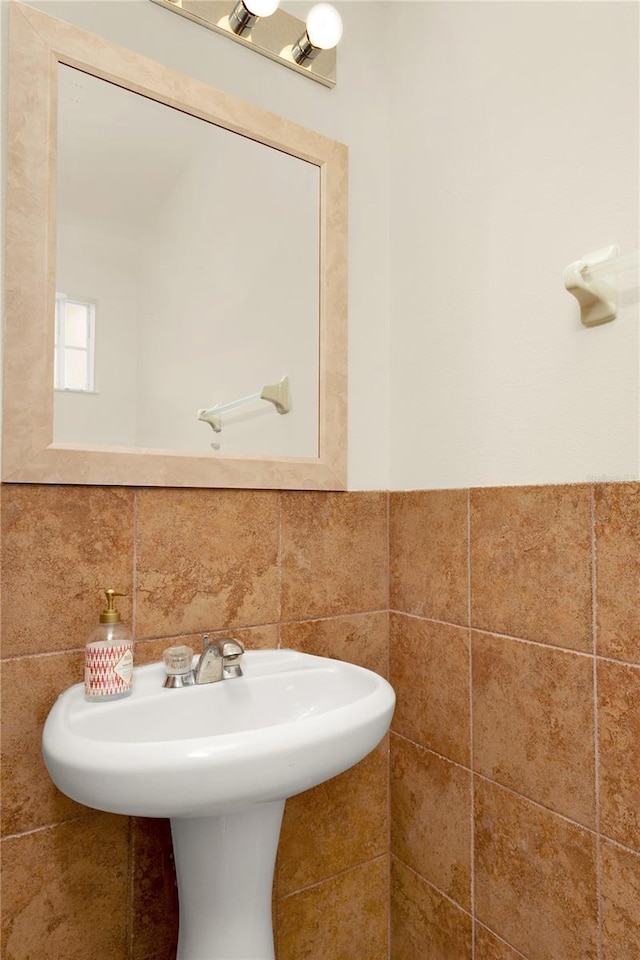 bathroom with tile walls and a sink