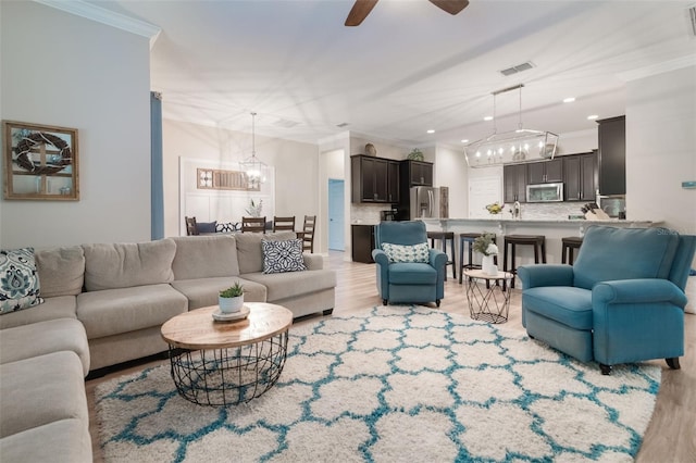 595 American Holly Pl, Oviedo, FL 32765 - living room with a chandelier, ornamental molding, light wood-style flooring, ceiling fan, and recessed lighting