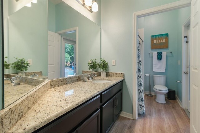 595 American Holly Pl, Oviedo, FL 32765 - bathroom featuring wood finished floors, baseboards, vanity, toilet, and curtained shower