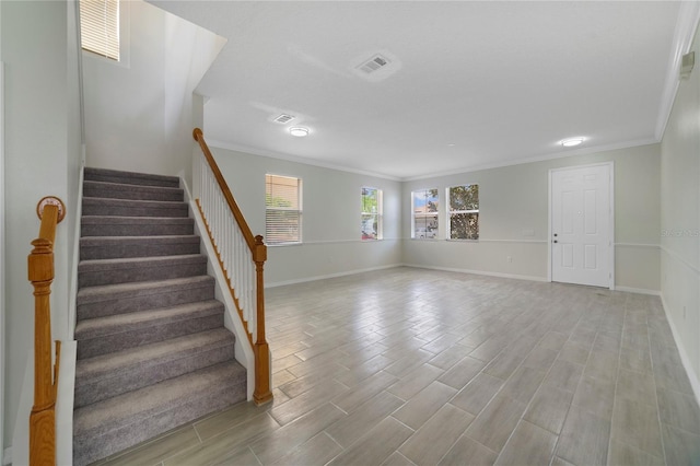 staircase featuring crown molding, baseboards, and wood finished floors