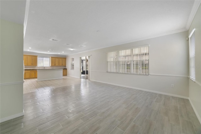 unfurnished living room featuring baseboards, light wood finished floors, crown molding, and recessed lighting