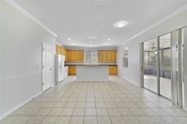 kitchen featuring crown molding, white fridge with ice dispenser, backsplash, a center island, and ceiling fan