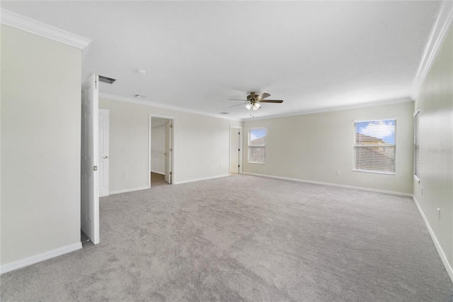 spare room with ornamental molding, carpet flooring, a ceiling fan, and baseboards