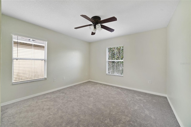 spare room featuring carpet, baseboards, a ceiling fan, and a textured ceiling