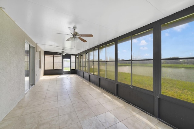 unfurnished sunroom with a ceiling fan and a water view