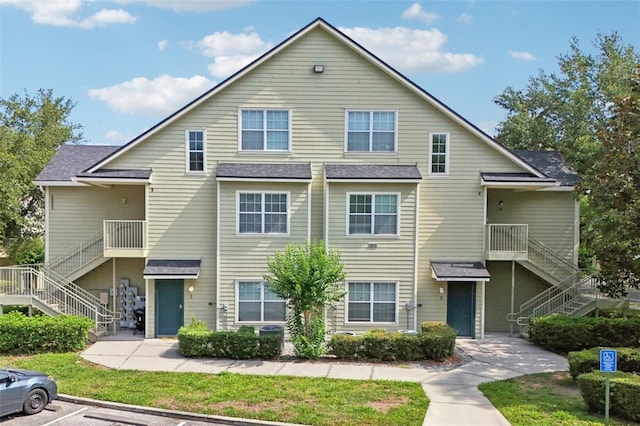 3721 S Lake Orlando Pkwy Unit 05, Orlando, FL 32808 - view of front of house with stairway, a shingled roof, and uncovered parking