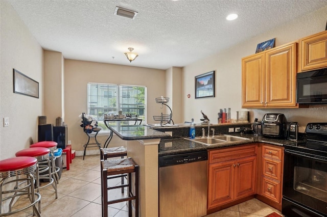 3721 S Lake Orlando Pkwy Unit 05, Orlando, FL 32808 - kitchen with black appliances, a sink, a peninsula, light tile patterned floors, and a textured ceiling
