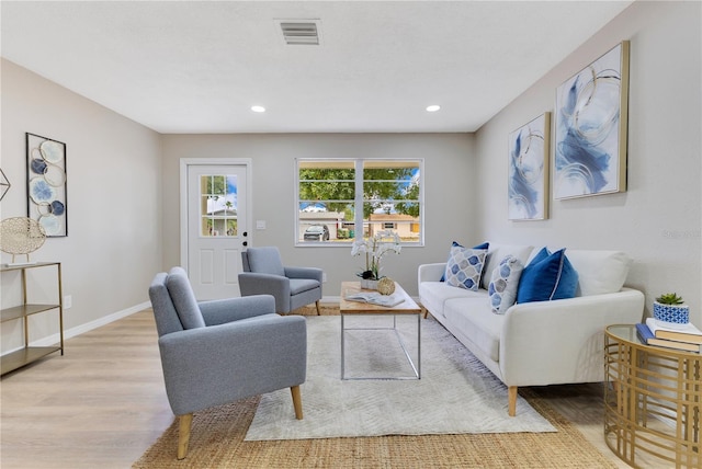 living area with light wood-type flooring, baseboards, and recessed lighting