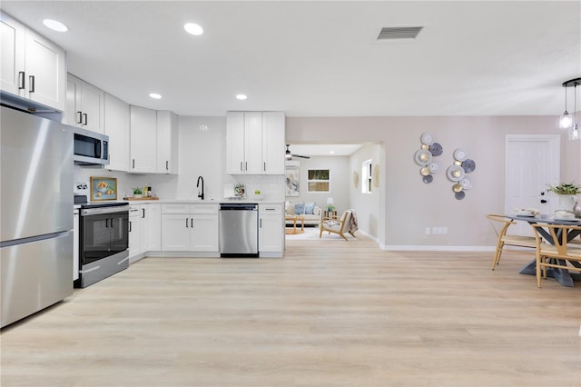 kitchen with stainless steel appliances, baseboards, light wood-style floors, white cabinetry, and recessed lighting
