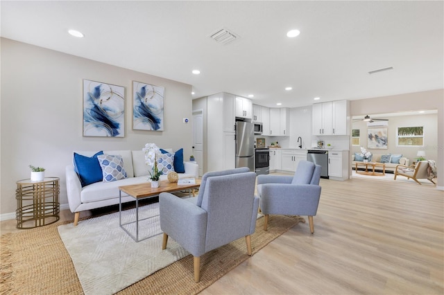 living room with recessed lighting, baseboards, light wood-style floors, and a ceiling fan