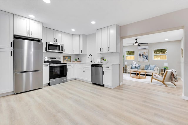 kitchen with stainless steel appliances, recessed lighting, light wood-style floors, light countertops, and white cabinetry