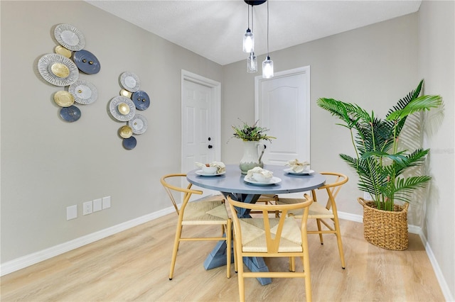 dining area featuring light wood-style floors and baseboards
