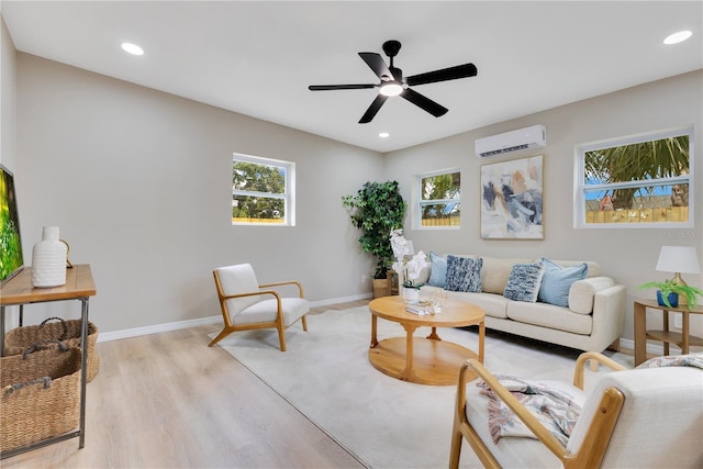 living room with a wall mounted air conditioner, ceiling fan, light wood-type flooring, recessed lighting, and baseboards