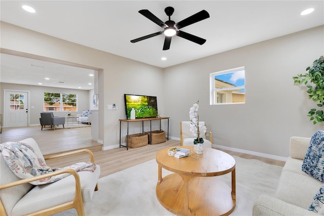 living room with light wood-style flooring, recessed lighting, baseboards, and a ceiling fan