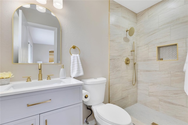 full bath with tiled shower, toilet, and vanity