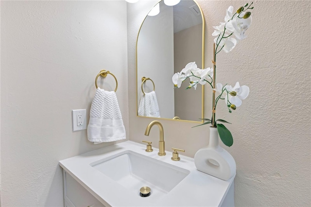 bathroom with vanity and a textured wall