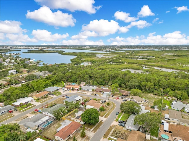aerial view of property and surrounding area featuring a nearby body of water and nearby suburban area