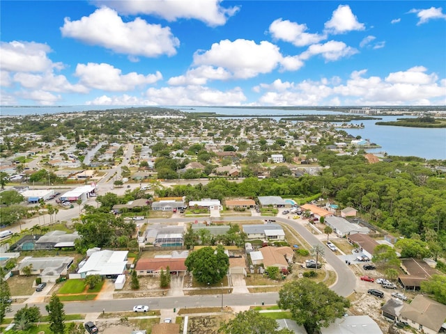 aerial view of property's location featuring a large body of water and nearby suburban area