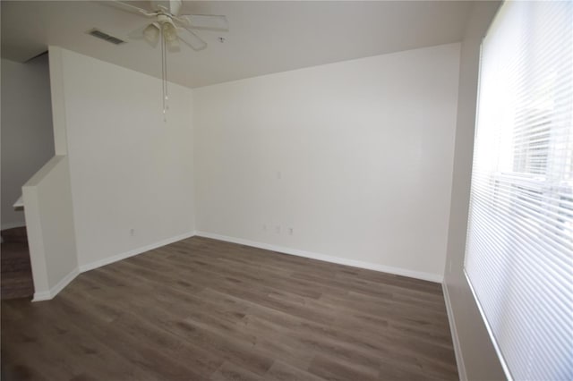 empty room with ceiling fan, wood finished floors, and baseboards