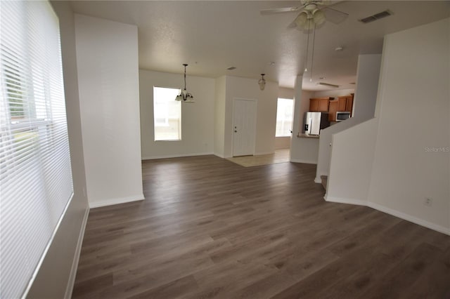unfurnished living room featuring wood finished floors, ceiling fan, and baseboards
