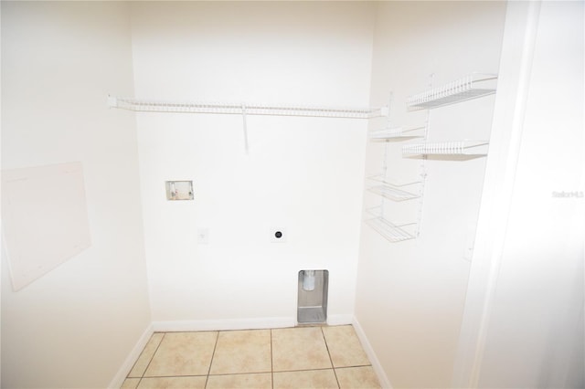 laundry area featuring electric dryer hookup, washer hookup, light tile patterned flooring, and baseboards