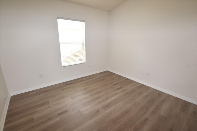 empty room featuring baseboards and wood finished floors