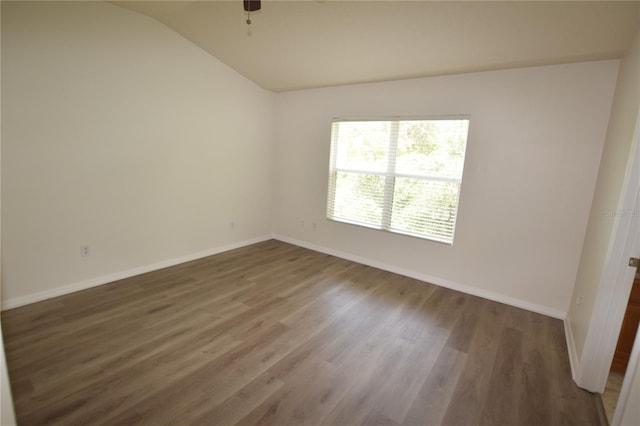 spare room with lofted ceiling, baseboards, wood finished floors, and ceiling fan