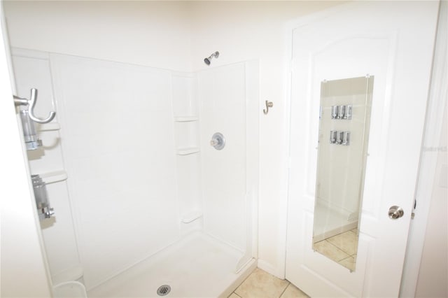 full bathroom featuring tiled shower and tile patterned floors