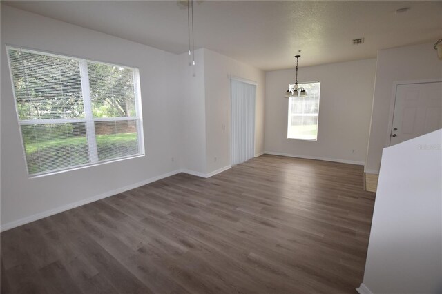15349 Oak Apple Ct, Winter Garden, FL 34787 - unfurnished dining area featuring a chandelier, healthy amount of natural light, wood finished floors, and baseboards