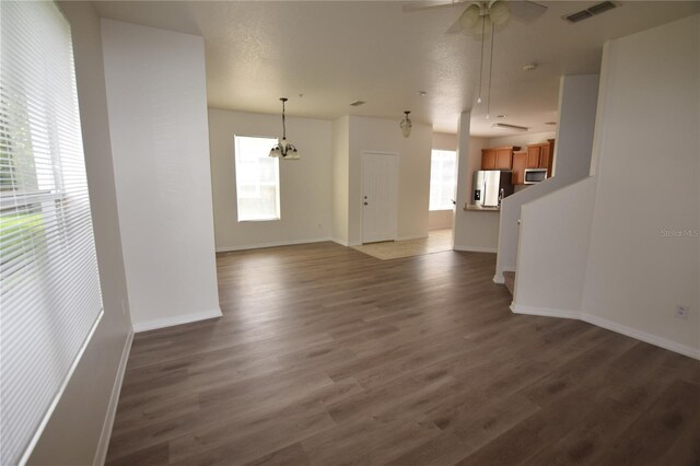 15349 Oak Apple Ct, Winter Garden, FL 34787 - unfurnished living room with wood finished floors, baseboards, a ceiling fan, and a chandelier