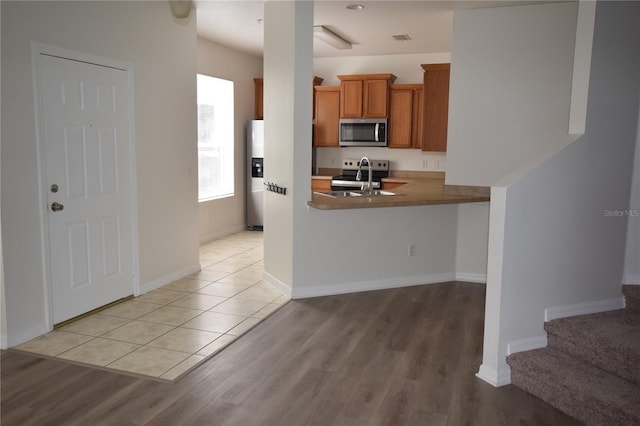 15349 Oak Apple Ct, Winter Garden, FL 34787 - kitchen featuring stainless steel appliances, brown cabinets, light wood-style flooring, and a sink