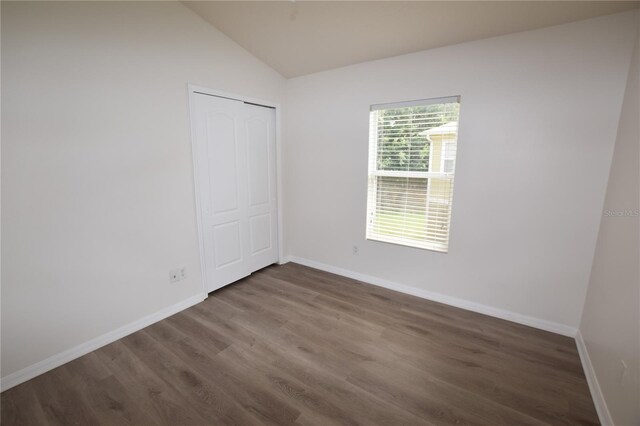 15349 Oak Apple Ct, Winter Garden, FL 34787 - unfurnished bedroom with wood finished floors, lofted ceiling, baseboards, and a closet