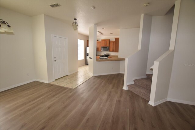 15349 Oak Apple Ct, Winter Garden, FL 34787 - unfurnished living room with light wood-style flooring, stairs, and baseboards