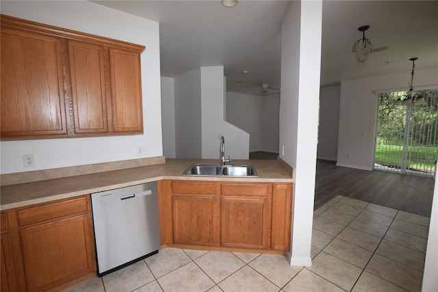 15349 Oak Apple Ct, Winter Garden, FL 34787 - kitchen featuring dishwasher, a sink, brown cabinets, light tile patterned floors, and light countertops