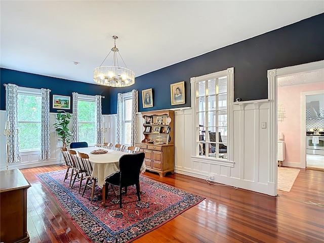 511 E Mirror Lake Dr, Fruitland Park, FL 34731 - dining room featuring a chandelier, hardwood / wood-style floors, a decorative wall, and a wainscoted wall