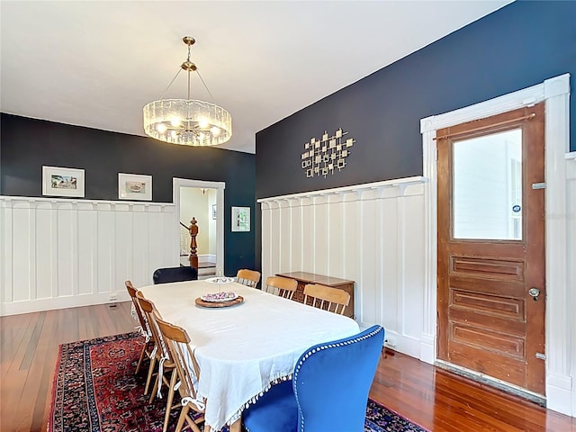511 E Mirror Lake Dr, Fruitland Park, FL 34731 - dining area featuring wood-type flooring, a chandelier, a wainscoted wall, and a decorative wall