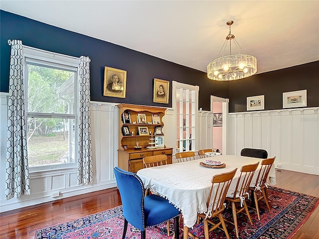 511 E Mirror Lake Dr, Fruitland Park, FL 34731 - dining space featuring wood finished floors, a chandelier, a wainscoted wall, and a decorative wall