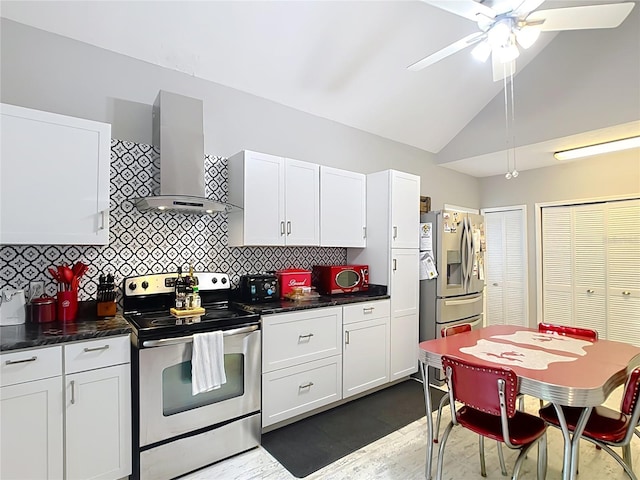 511 E Mirror Lake Dr, Fruitland Park, FL 34731 - kitchen with appliances with stainless steel finishes, wall chimney exhaust hood, a ceiling fan, dark countertops, and high vaulted ceiling