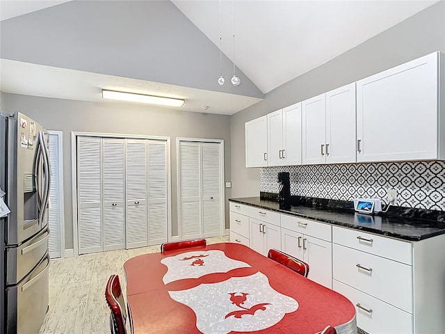 511 E Mirror Lake Dr, Fruitland Park, FL 34731 - kitchen with stainless steel fridge, lofted ceiling, wood finished floors, backsplash, and white cabinets