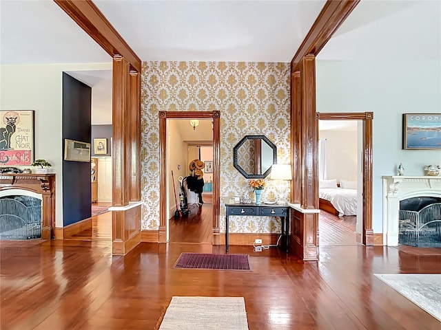 511 E Mirror Lake Dr, Fruitland Park, FL 34731 - living area featuring a fireplace, wood finished floors, wallpapered walls, and baseboards